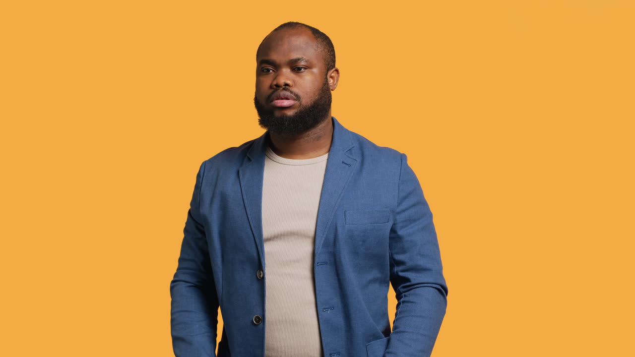 Stern man doing stop hand gesture sign, studio background