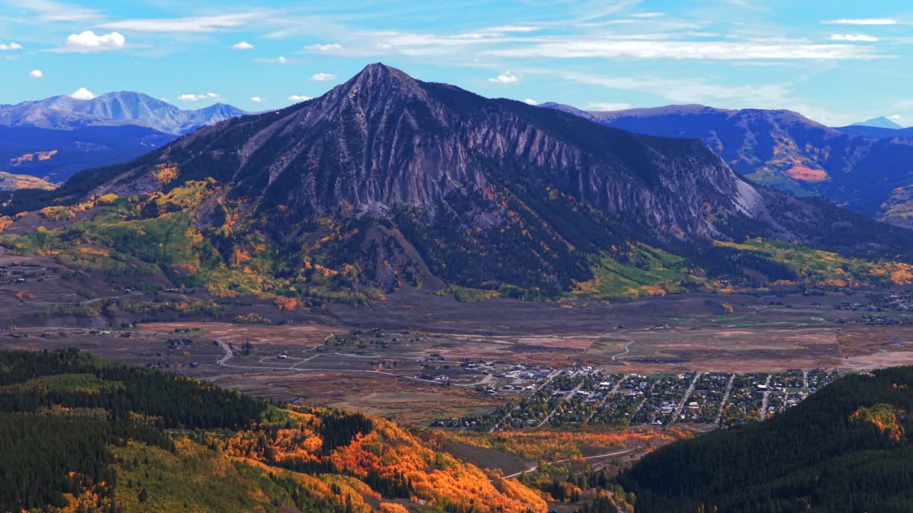 Crested Butte ski resort small Colorado Rocky Mountains down town Main Street drone aerial fall autumn Quaking Aspen Trees leaf peeping daytime blue skies clouds Coal Creek Kebler Pass backwards pan
