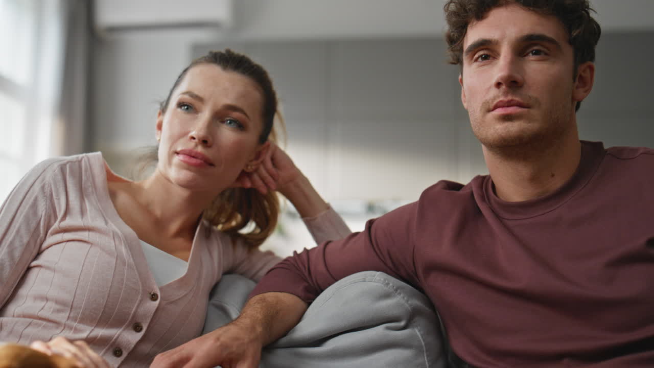 Lovely dog lying knees woman relaxing with husband closeup. Family caressing pet