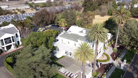 Panoramic-view-from-above-of-a-white-stylish-villa,-typical-for-weddings,-and-places-around