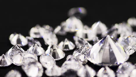 tiro em câmera lenta de verdadeiros diamantes de corte brilhante de tamanho médio caindo na mesa de classificação em uma joalheria