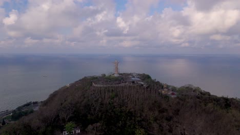 Monument of hilltop landmark Jesus overlooking the sea at Vung Tau, the entrance of Mekong Delta, Vietnam. Drone rotate.