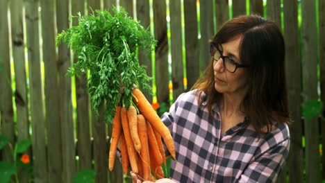 Mature-woman-holding-carrot-vegetable-4k