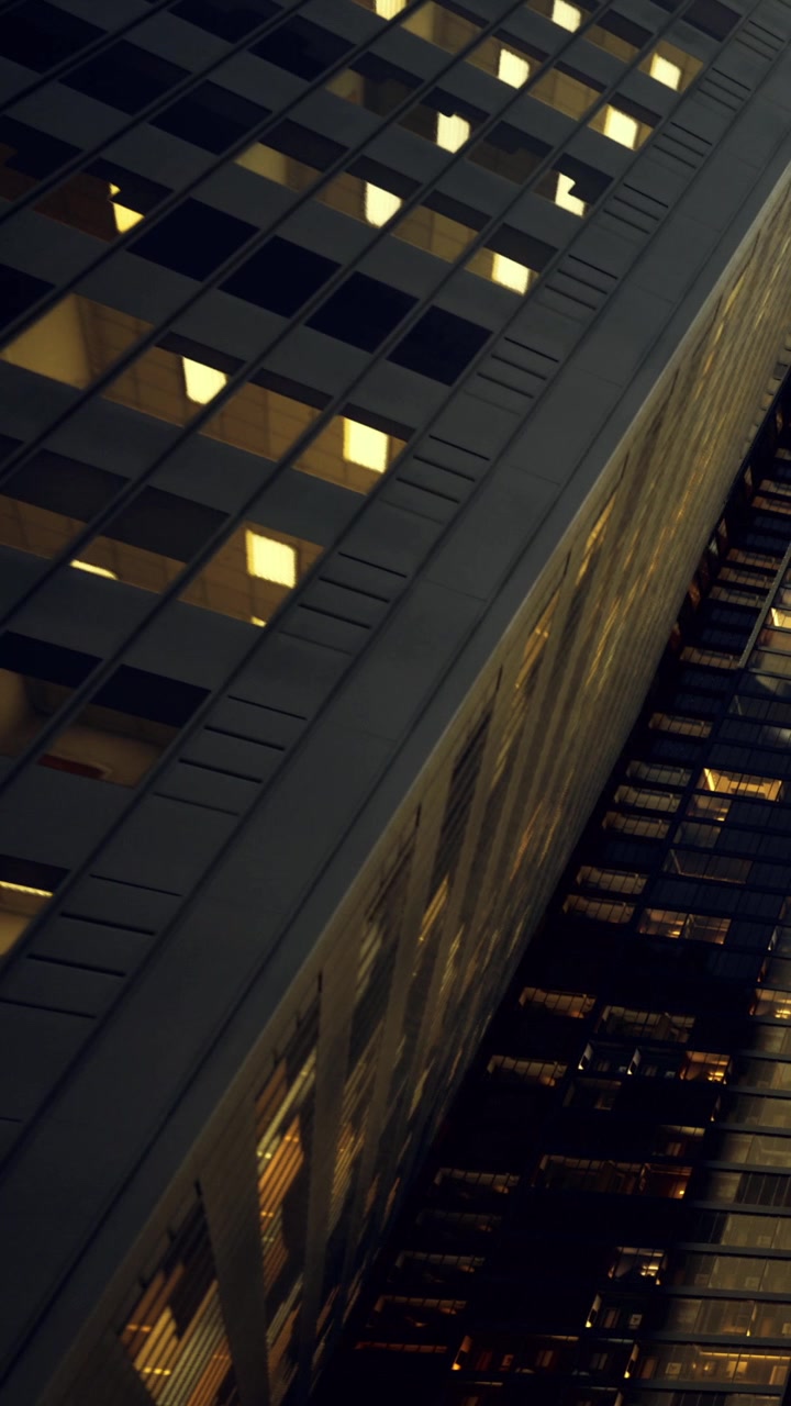 City buildings at night with lights shining from some windows