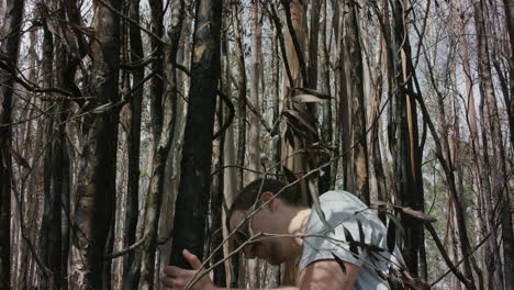 Joven-Inspeccionando-Un-árbol-Quemado-Tras-Un-Incendio-Forestal-En-Australia