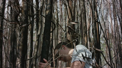 Young-man-inspecting-burnt-tree-in-Australian-bushfire-aftermath