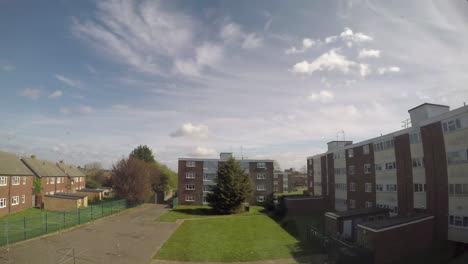 a timelapse overlooking a green open area behind two blocks of council flats