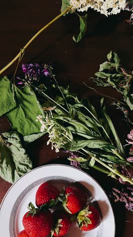 fresh strawberries and dried flowers on a wooden table