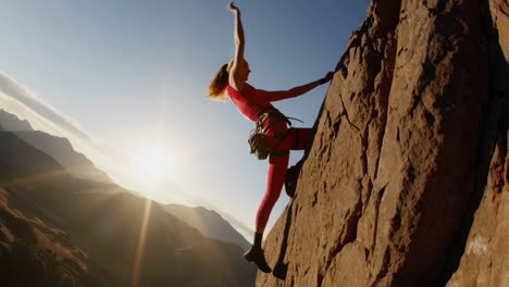 woman rock climbing on a sunny mountain face