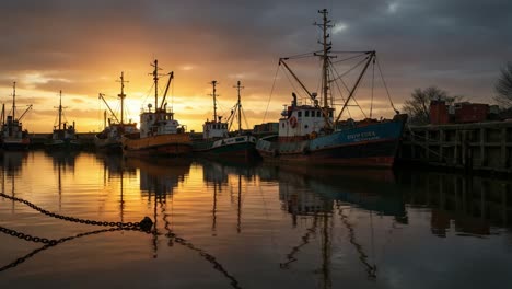 a serene sunset view showcasing vibrant colors reflecting off calm waters, with boats anchored peacefully along the shoreline, creating a picturesque harbor scene