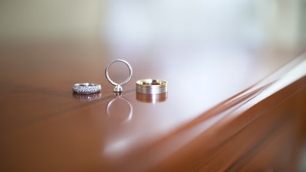 Elegant Wedding and Engagement Rings on Polished Wooden Surface