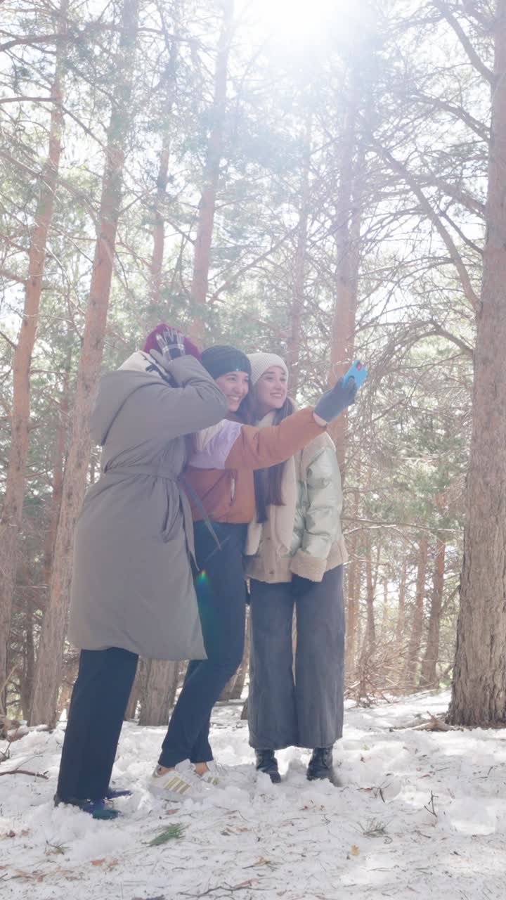 Three women taking a selfie in a snowy forest