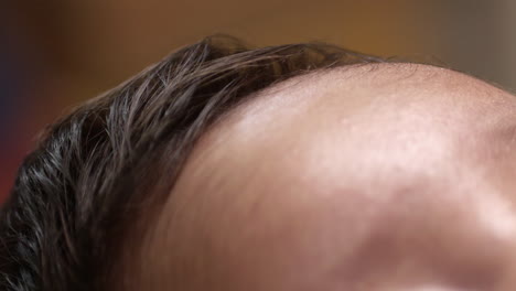 tender close-up of a 2-month-old baby girl’s hair, forehead, and soft skin