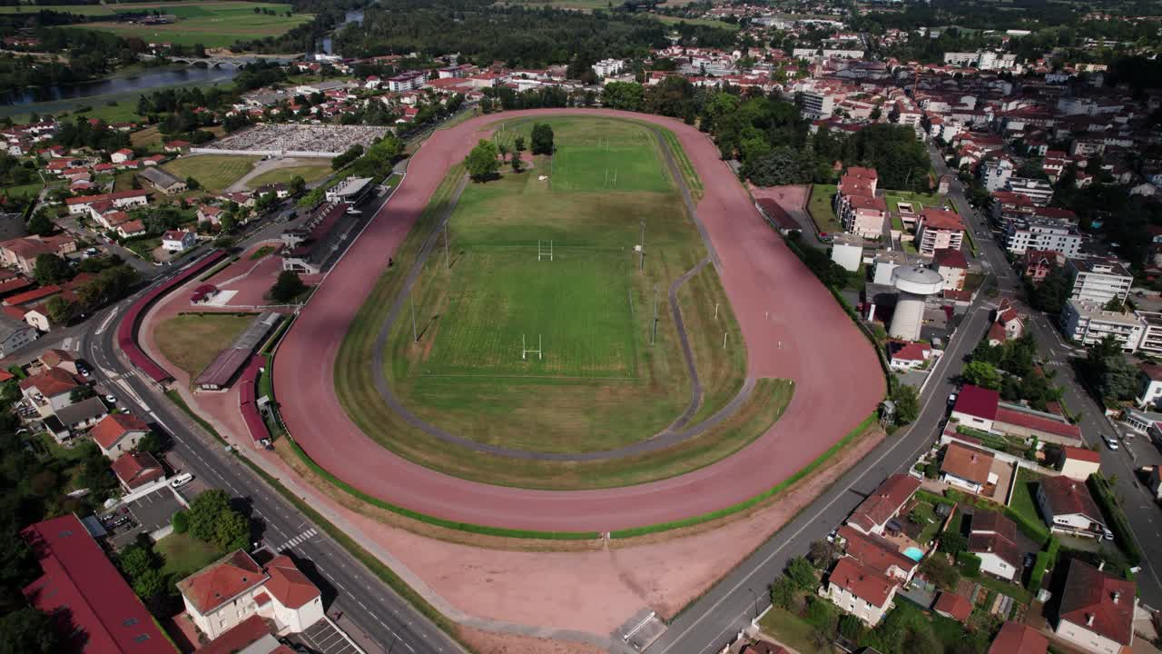 fotografía aérea hacia atrás revelando el hipódromo de la ciudad de feurs y la ciudad en el fondo, provincia de forez, departamento de loira, auvergne, región de ródano alpes, francia