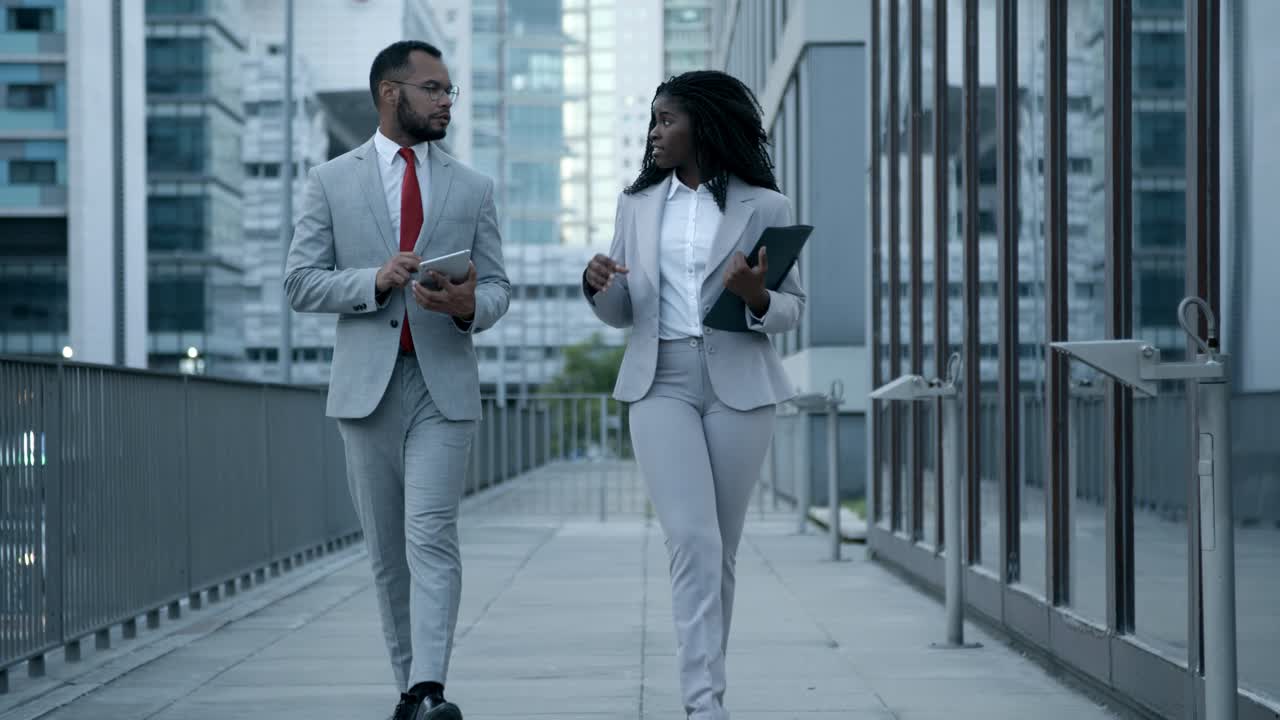 Front view of managers walking on street and talking