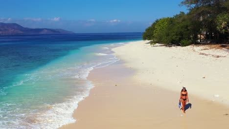 Young-girl-wearing-snorkel-set-walking-on-exotic-beach-of-tropical-island,-seeking-for-ideal-location-to-dive-into-clear-turquoise-lagoon-in-Ko-Samui,-Thailand