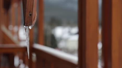 Scharfe-Eiszapfen-Oder-Stalaktiten-Gefroren-Hängend-Auf-Holzbalkon,-Nahaufnahme