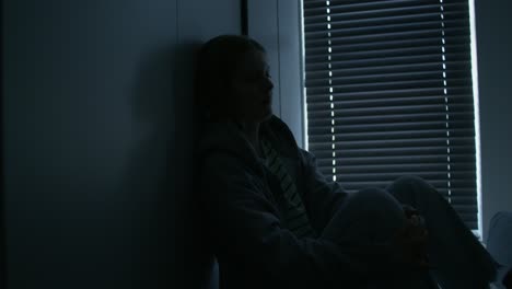 woman sitting alone in dark room