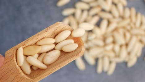 pine nuts on wooden spoon