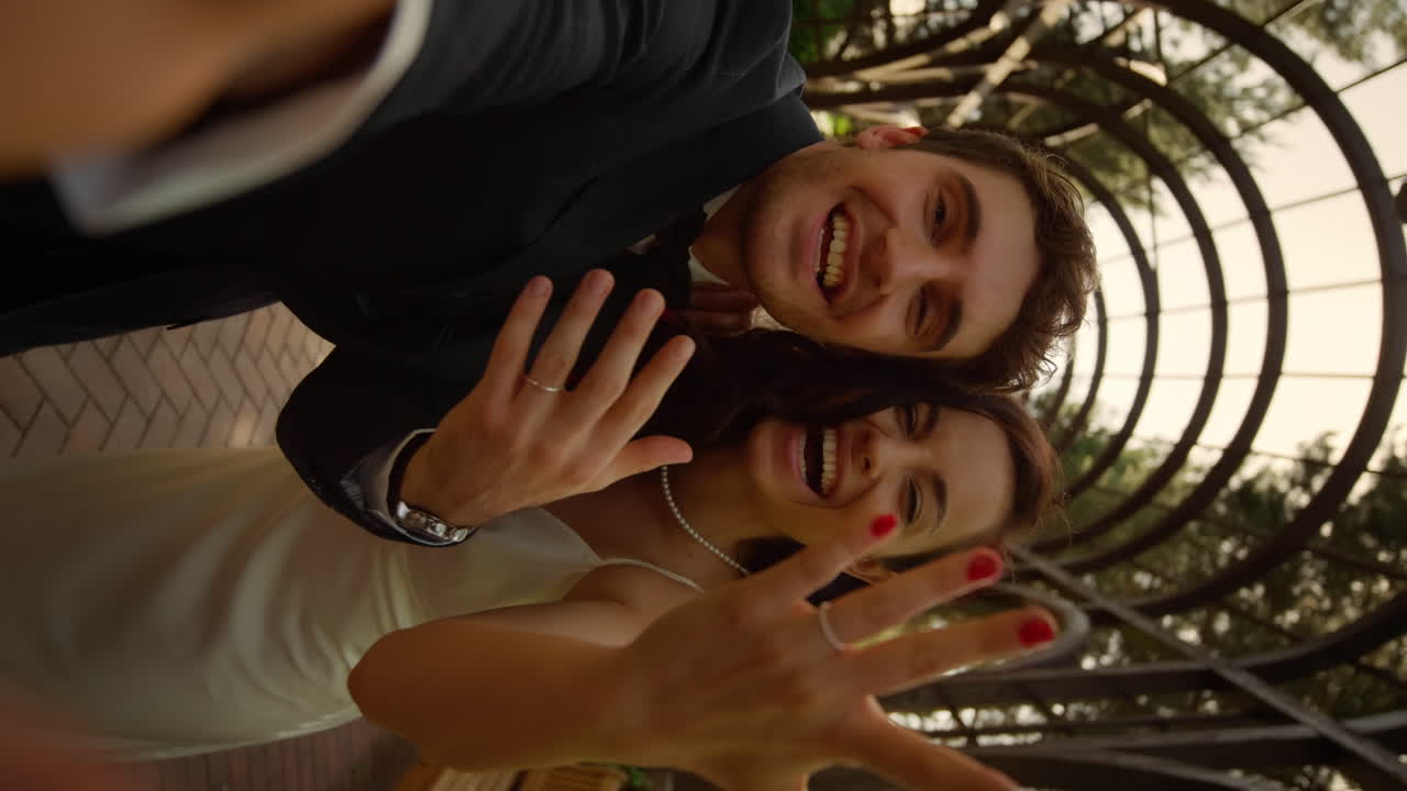 Novia morena enviando besos. Pareja anunciando su matrimonio al aire libre.