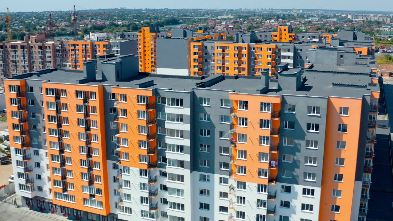 Facade of a modern apartment building. Colorful walls of a new multi-storey building with balconies and windows. High residential building in sunny day.