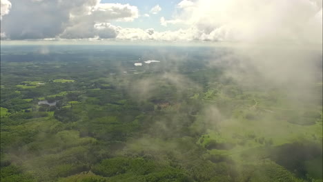 the drone elegantly captures a magnificent landscape, showcasing the picturesque valleys, complimented by an enchanting forest, while being accentuated by the ethereal white clouds