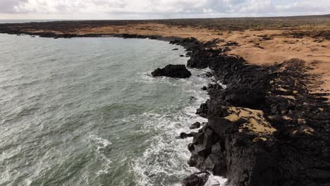 aerial view of rugged volcanic coastline near búðakirkja, búðir, snæfellsnes peninsula, iceland, where dark lava cliffs meet the wild north atlantic.