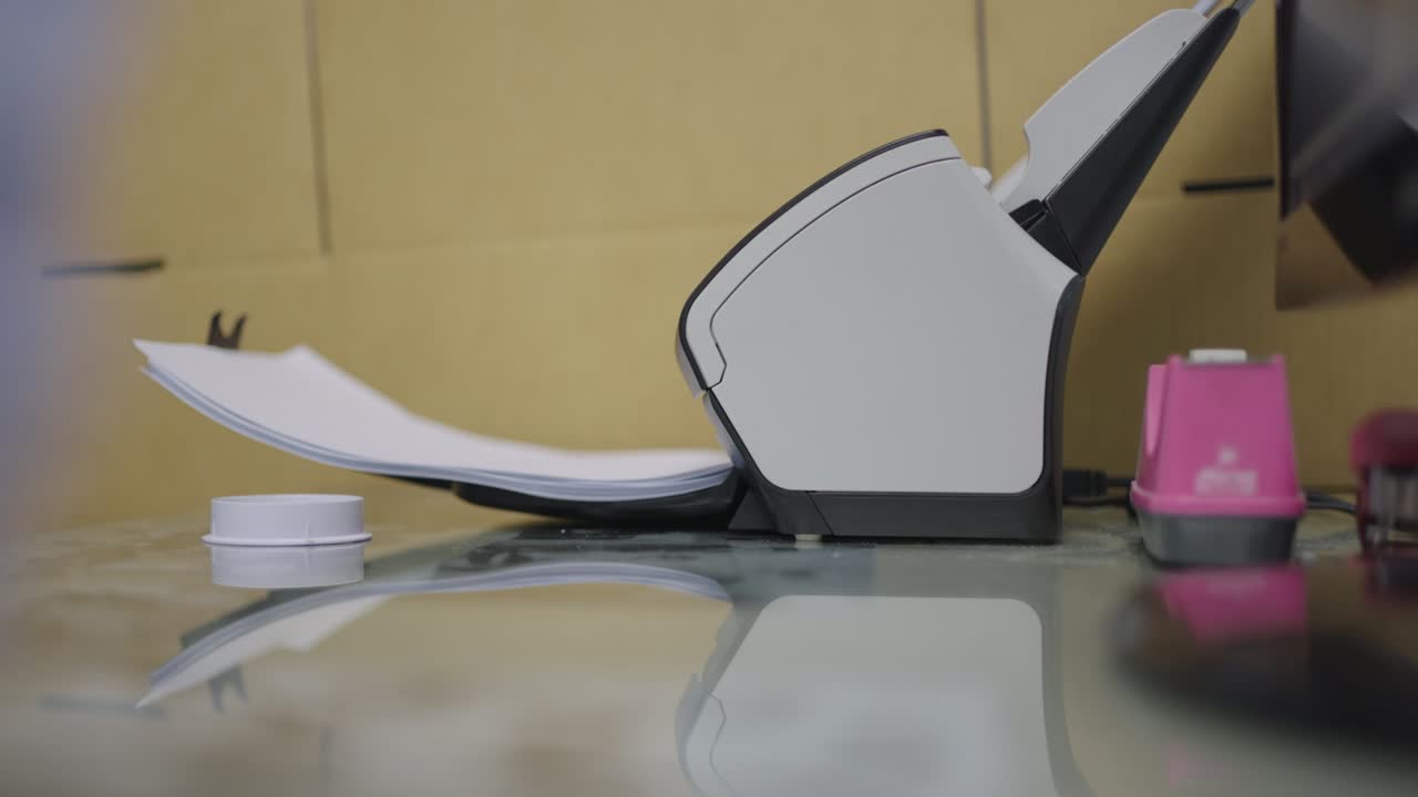 Close-up scanner machine is scanning documents to convert paper to information data digital into computer.