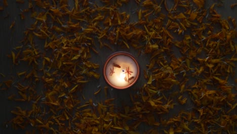 human hand using a matchstick to light a diya used for various hindu festive celebrations for the festival of light- diwali and also for others like dussehra or prayers at home or a temple