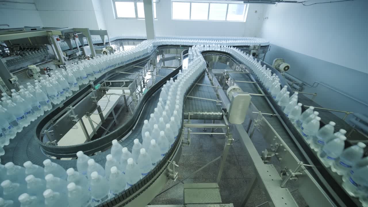 Conveyor belt with bottles of drinking water at a modern beverage plant