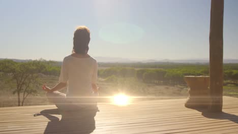 Animation-Von-Lichtflecken-über-Einer-Kaukasischen-Frau,-Die-Yoga-Praktiziert-Und-Meditiert