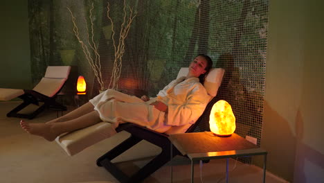 adult caucasian woman relaxing in lounge chair in wellness spa complex, static