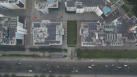 aerial top view of corporate buildings near a highway filled with moving traffic