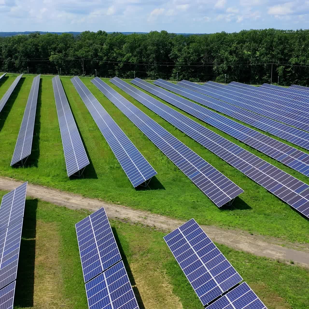 Motion camera view of the solar panels with blue sky background. Alternative energy. Green energy concept. Electricity production. Eco plant. Aerial view on cell