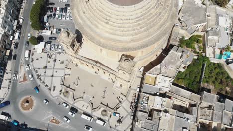 bird's-eye view aerial 4k drone footage flying over the mosta rotunda dome, a roman catholic church, and it's surrounding city of malta