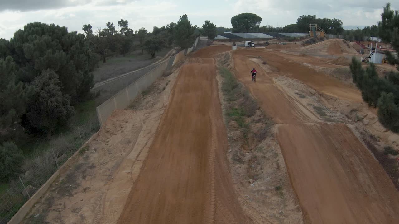 seguimiento aéreo en cámara lenta de pilotos de motocross llenos de adrenalina en la pista