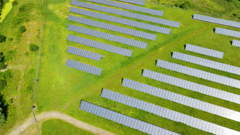 aerial view of solar panels stands in a row in field for power production