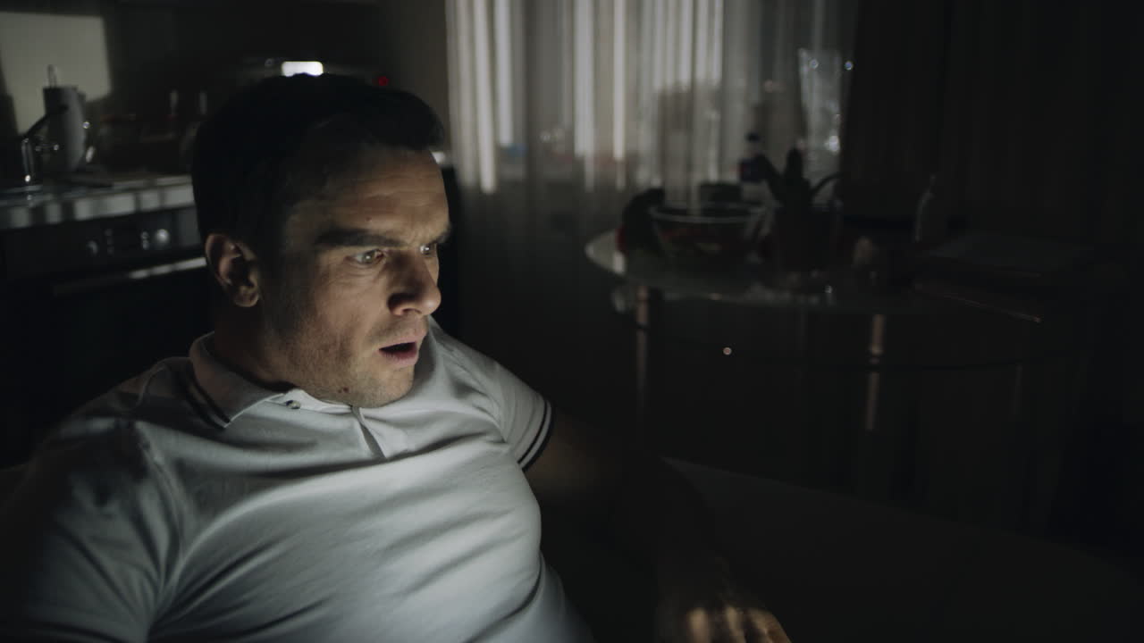 un hombre asustado encuentra noticias impactantes en la oficina nocturna.