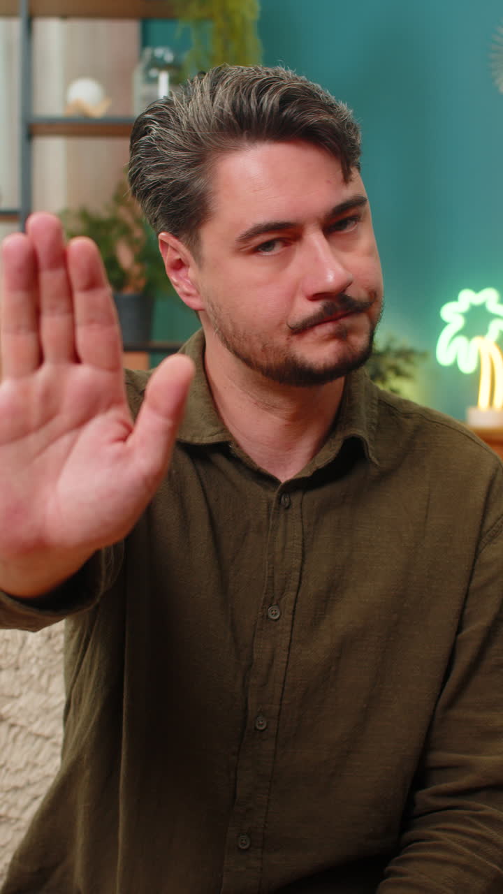 Middleaged man stop hand gesture staring serious signaling halt caution demanding negative response