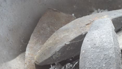 molten lead being poured into a mold with visible steam, close up