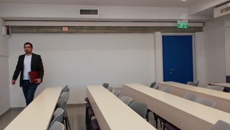 young male teacher arriving in classroom