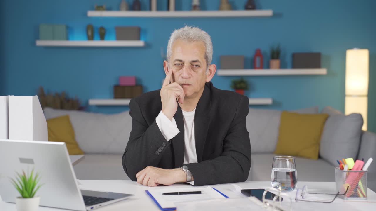 trabajador de oficina en casa pensando mirando a la cámara.