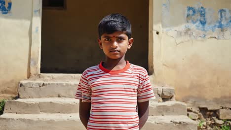 portrait of a young boy standing in front of his house in a rural village, representing the simplicity and resilience of childhood in developing countries