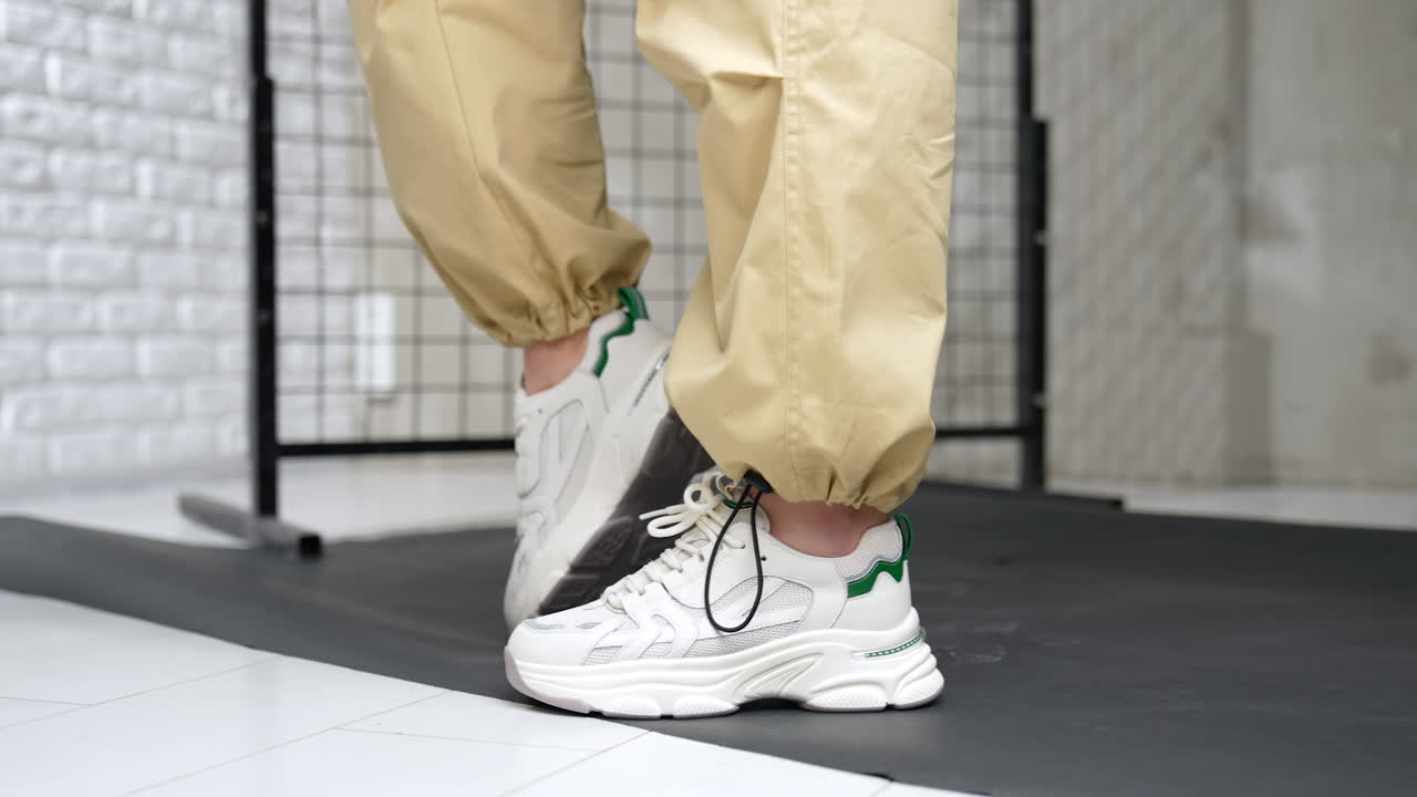 White fashionable shoes for sport. Trendy female footwear presentation in the studio. Close up.