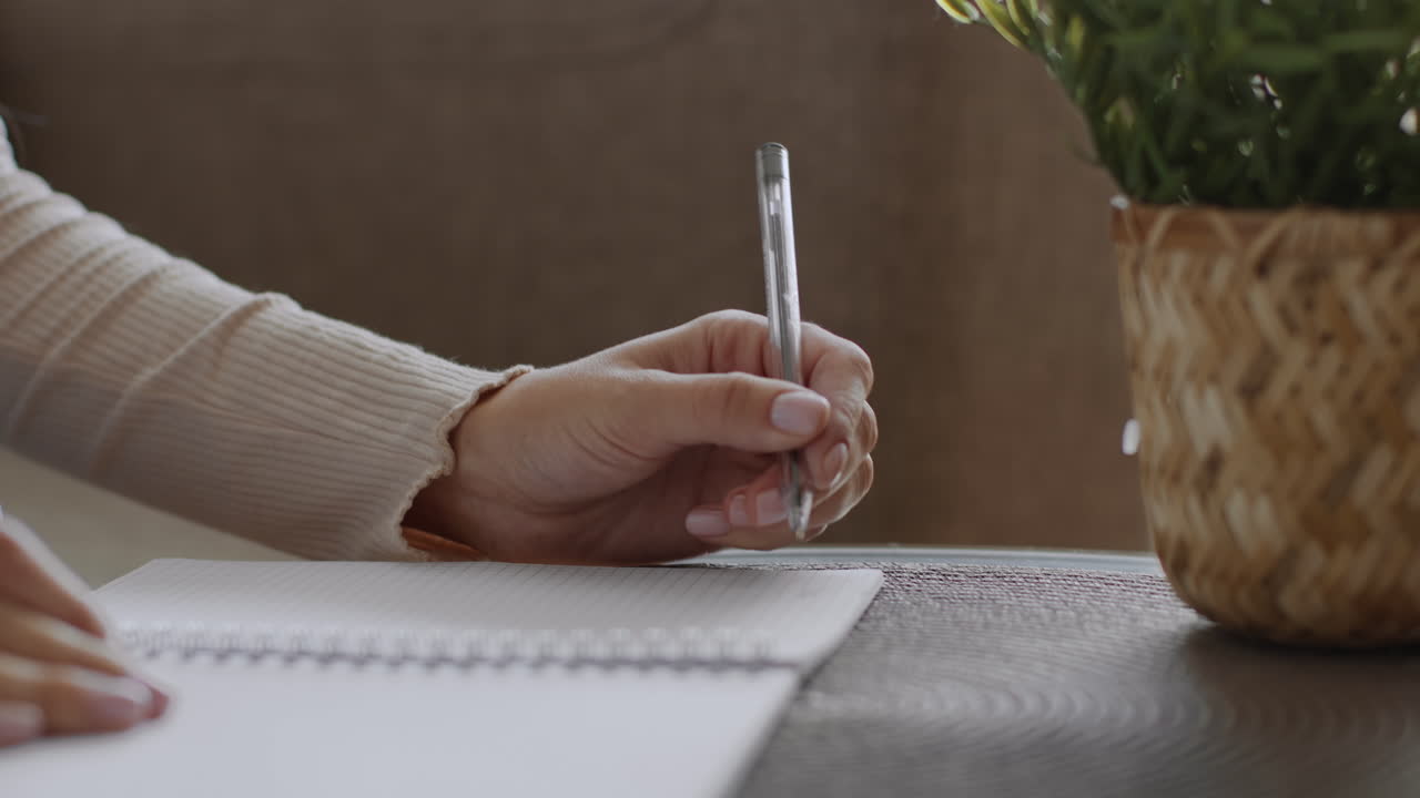 Woman Writing in a Notebook at Home