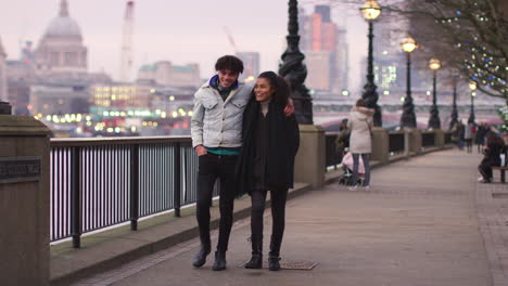 couple walking along south bank on winter visit to london