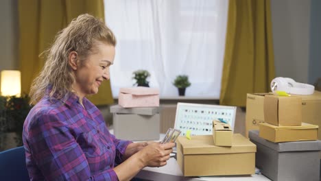 woman selling in her online store is counting money.