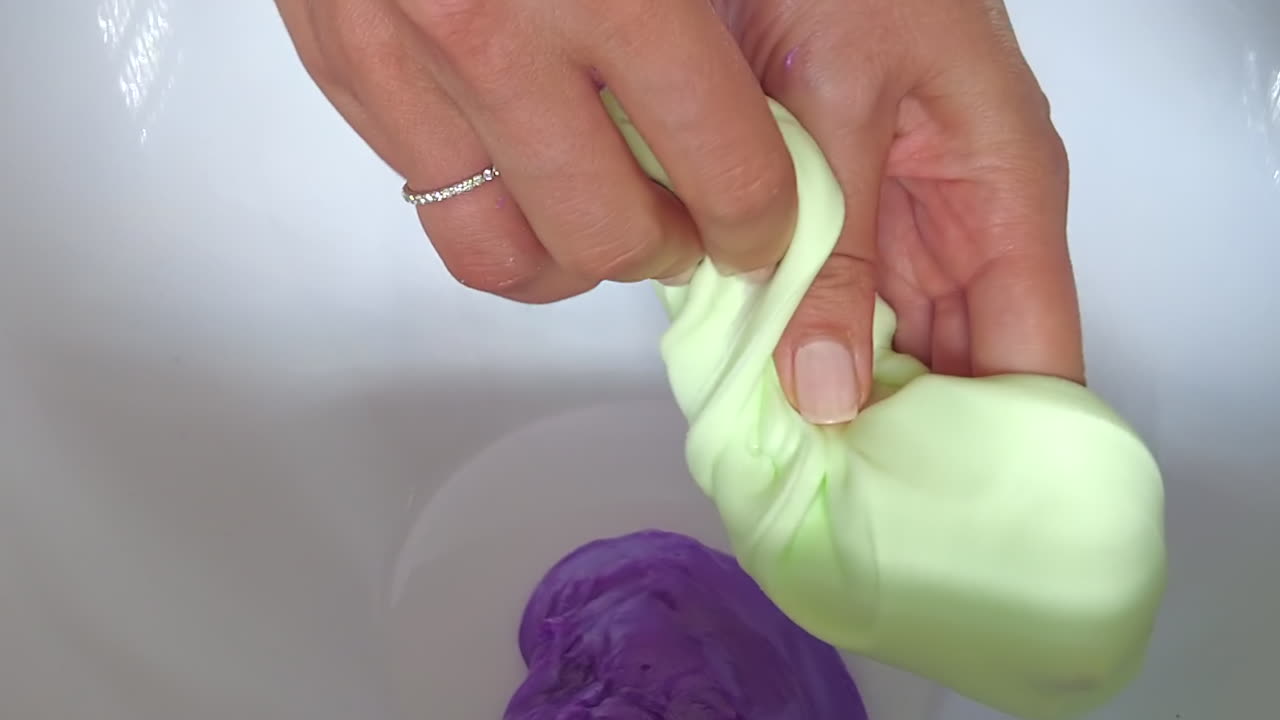 Woman playing with green slime on a white background