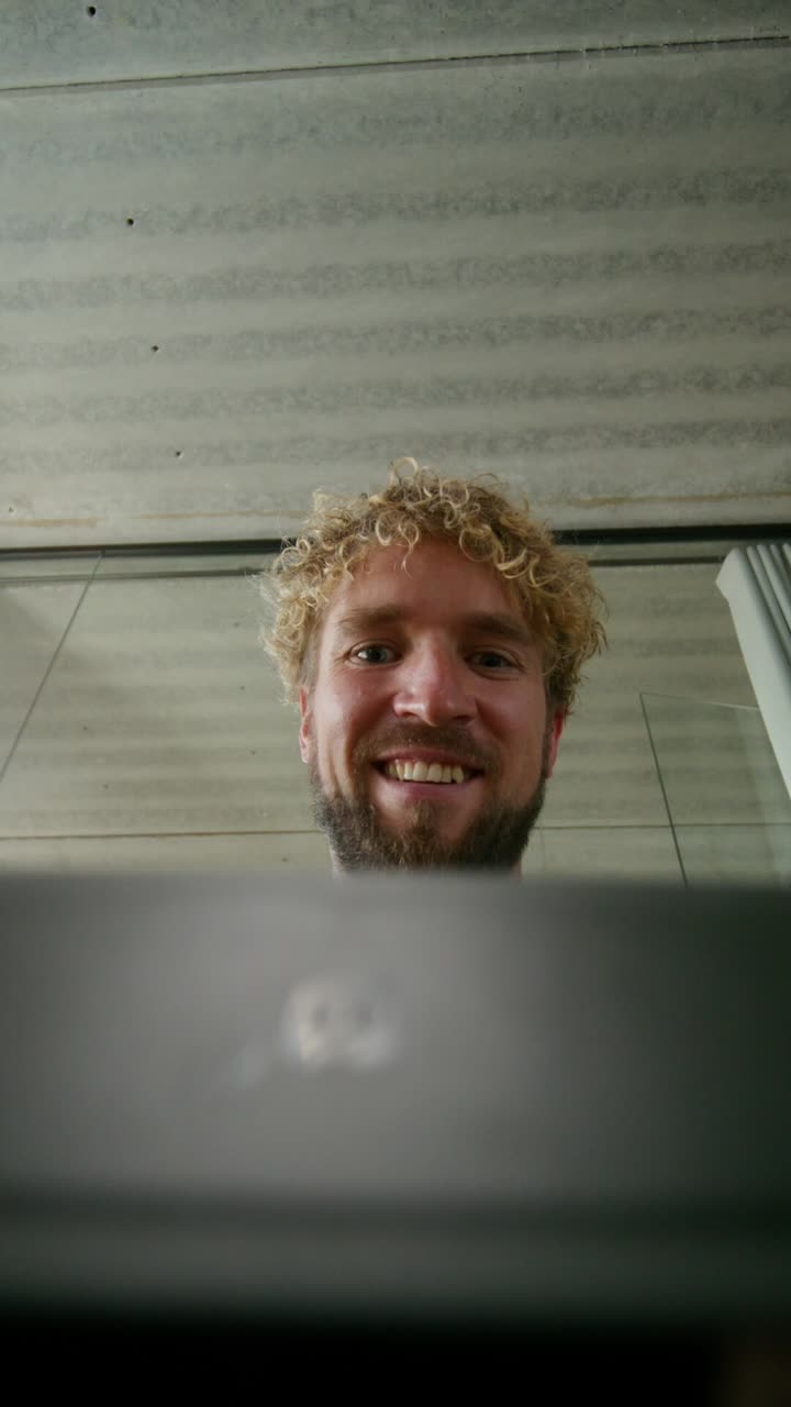 hombre mirando el monitor de la computadora y sosteniendo el papel