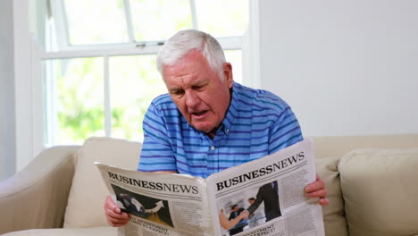 un hombre maduro leyendo su periódico.